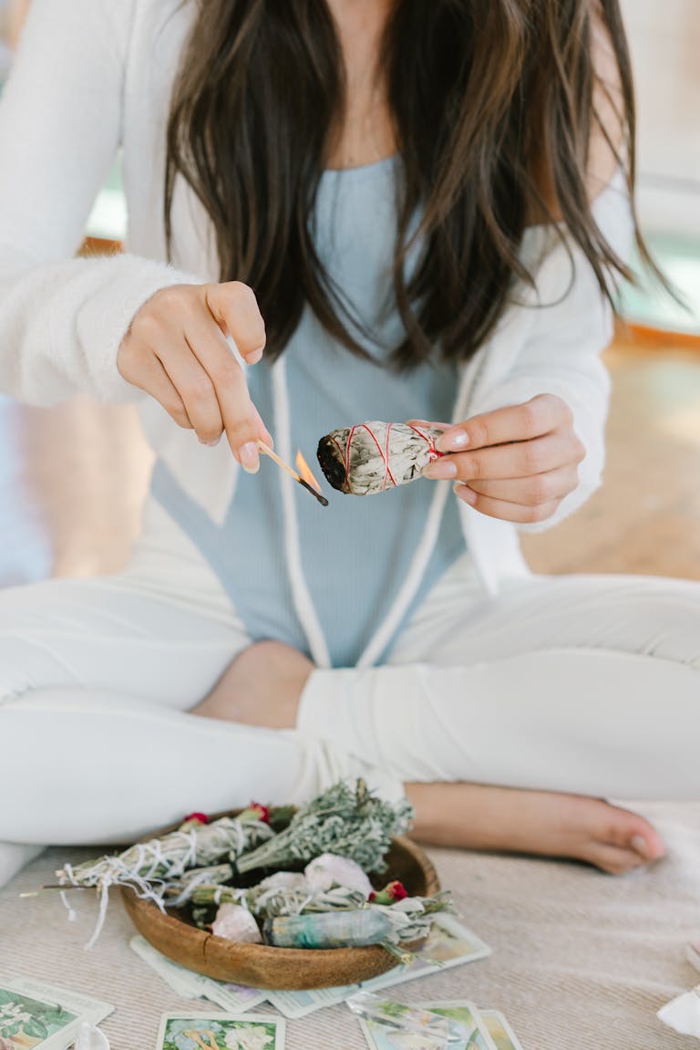 A serene scene of a woman meditating with burning sage and tarot cards.